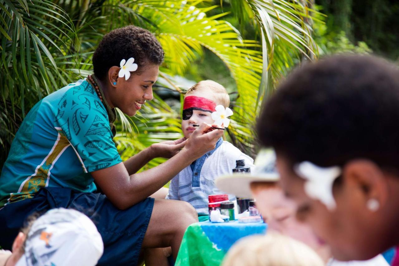 Outrigger Fiji Beach Resort Korotogo Eksteriør billede A young woman from the Cook Islands applying titi muka to a child's face